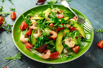 Fresh Avocado, shrimps salad with lettuce green mix, cherry tomatoes, herbs and olive oil, lemon dressing. healthy food