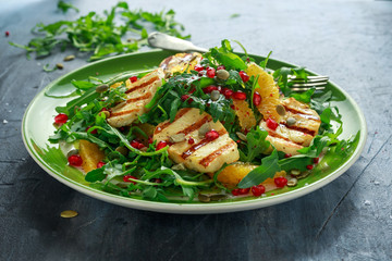 Grilled Halloumi Cheese salad with orange, rocket leaves, pomegranate and pumpkin seed. healthy food