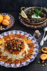Iranian wedding pilaf topped with nuts, orange zest and raisins, rustic style