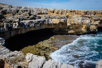 Fototapeta na wymiar Natural marine cave along rocky shore in Polignano. Apulia, Italy