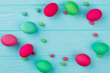Frame from colorful eggs and candies. Dyed Easter eggs and colorful sweets with copy space in center. Happy Easter holidays.
