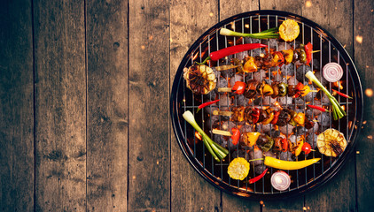 Top view of fresh meat and vegetable on grill placed on wooden floor.