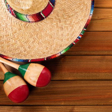 Mexico cinco de mayo background border square format with sombrero straw hat traditional rug or blanket and maracas on an old dark wood background fiesta carnival photo