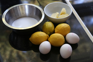 zutaten für lemon curd auf einer schwarzen arbeitsplatte