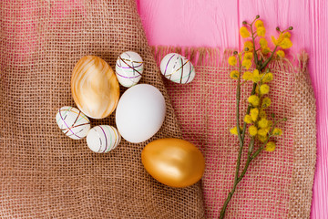 Decorative Easter eggs on burlap. Festive Easter spring composition with pussy-willow and eggs. Easter decorations ideas.