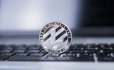 Litecoin coin on a laptop in centre of the frame. Litecoins crypto currency on a laptop black keyboard. Digital currency. Virtual money. Metal coins of litecoin. Bussiness, commercial, Exchange.