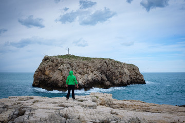 Girl looks at the hermit's isle. Coast of Polignano. Apulia, Italy.
