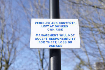 Vehicles and contents left at owners risk sign post responsibility theft loss damage at workplace workers security office