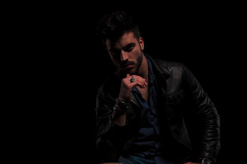 close up of fashion man in leather jacket thinking