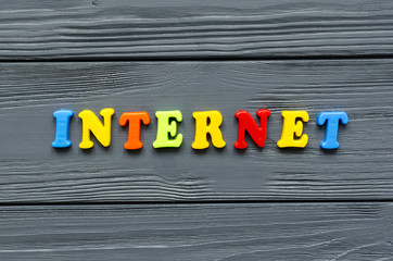 word "internet" of colored plastic magnetic letters on grey wooden background