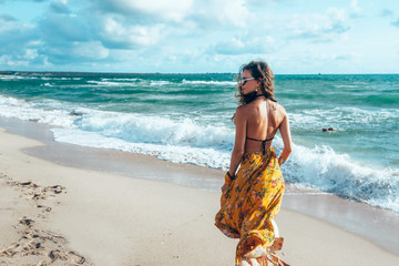 Boho girl walking on the beach