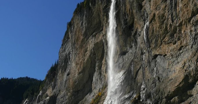 Waterfall, Cinema 4k tilt view of the a water fall, in lauterbrunnen town, in berner oberland, in the swiss alps of Switzerland