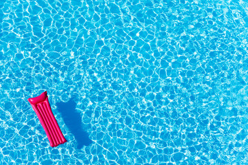 Pink inflatable mattress floating on water surface