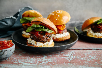 Burgers with grilled beef patties, cream cheese and spinach on classical bun.