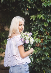 Blond beautiful girl with bouquet of flowers.