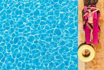 Fototapeta na wymiar Attractive woman enjoying suntan by swimming pool