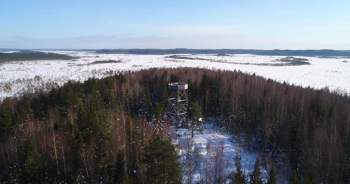 Watchtower, Cinema 4k aerial view over a nature observation tower, a forest and a huge swamp, on a winter day, in Torronsuo national park, Kanta-hame, Finland