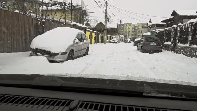 winter weather in the city, on the car road - falling snow. POV windshield view
