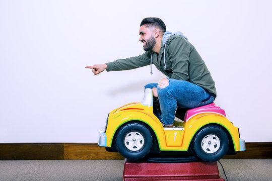 Cheerful man riding on kids car