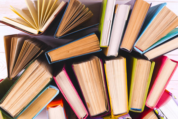 Naklejka premium Open book, hardback books on bright colorful background.