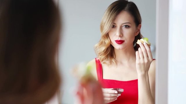 Young redhead woman eating a cake