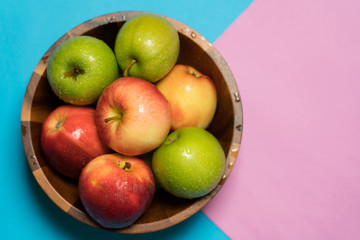 Place the apples on a blue and pink paper.