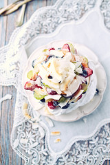 Homemade Pavlova with Fresh Fruits and Coconut; Cake with blueberries, strawberries, grapes, raspberries and coconut
