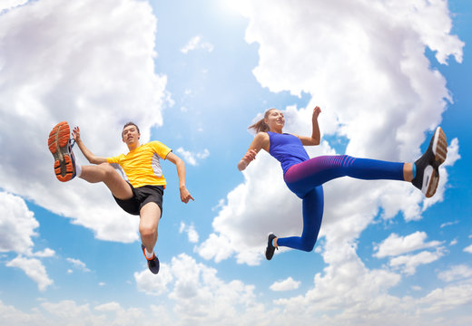 Athletes remains in air while jumping against sky