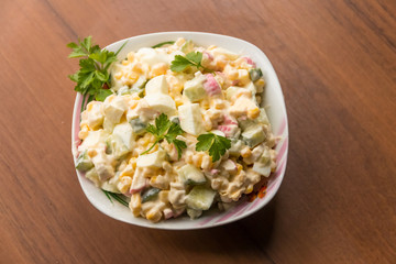 Salad with crab sticks, sweet corn, cucumber, eggs and mayonnaise