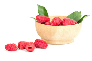 ripe juicy raspberries with leaves in a plate on white table