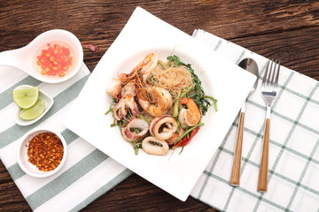 noddle tom yum seafood in white plate