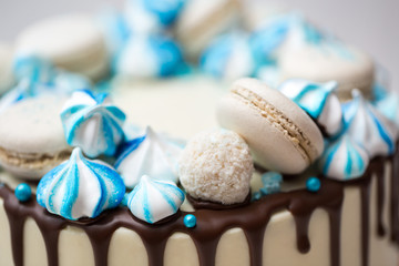 Cake with chocolate streaks, blue meringue and macaroons