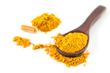 Turmeric powder on a wooden spoon isolated on white background