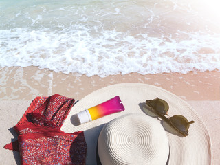 Hat, sunglasses and sunscreen at the side of a beach, summer travel concept