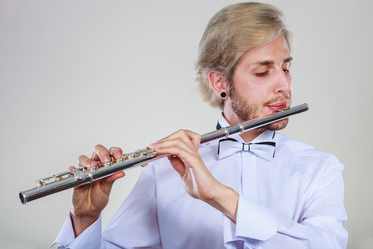 Male flutist playing his flute
