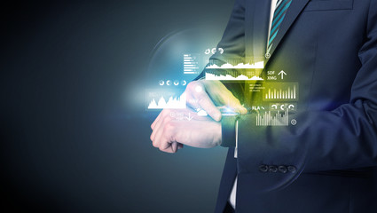 Businessman wearing smartwatch with graphics and charts on it.