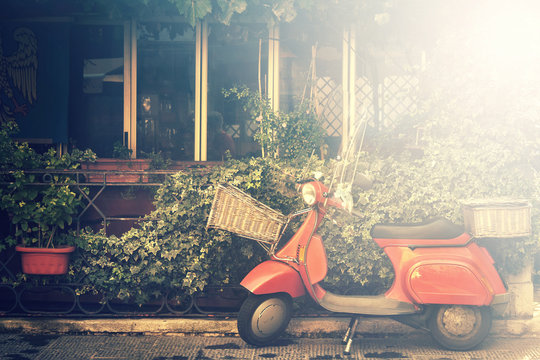 italian scooter, traditional style motorcycle with foliage background (image with bright light effect)