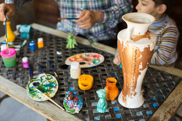 Father and son paint a vase