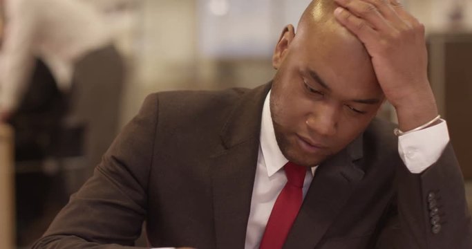 A young African American stockbroker is stressed after making a huge loss.