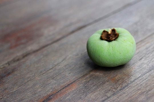 Diospyros decandra  Lour. Green thai fruit  on wooden table