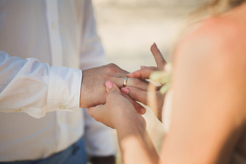 Fototapeta na wymiar bride wears a ring on the groom's finger