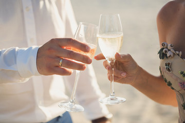 Bride and groom are holding champagne glasses