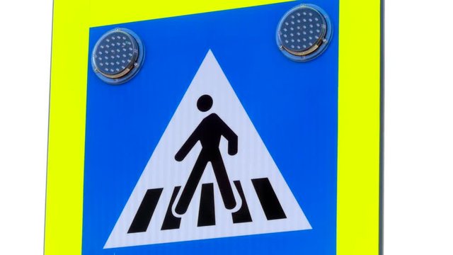 Led warning bulbs on blue pedestrian cross walking traffic sign .