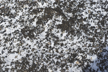 The texture of the winter asphalt with snow. Winter mottled background
