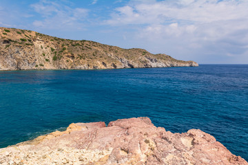 Fototapeta na wymiar Rocks and blue sea water in Firopotamos Bay on Milos, Cyclades Islands, Greece.