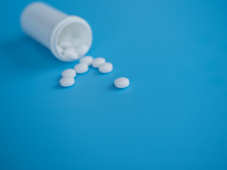Sorted pharmaceutical vitamins, tablets and pills used in medicine for treatment lie on a light blue background