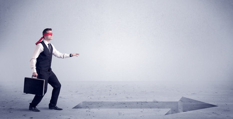 A confused blind salesman standing in front of a drawn arrow on the floor pointing in the right direction concept.