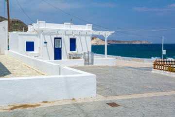 Typical whitewashed Greek house overlooking blue sea in Mandrakia bay. Milos island, Greece © vivoo