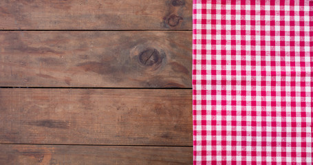 Red classic Checkered tablecloth on wooden rustic  table, background with copy space.