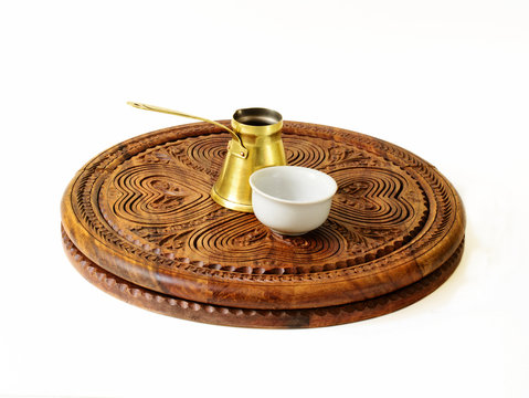 Ibrik (Turkish coffee pot) and a fildzan (Turkish coffee cup) on a beautiful carved wooden salver.